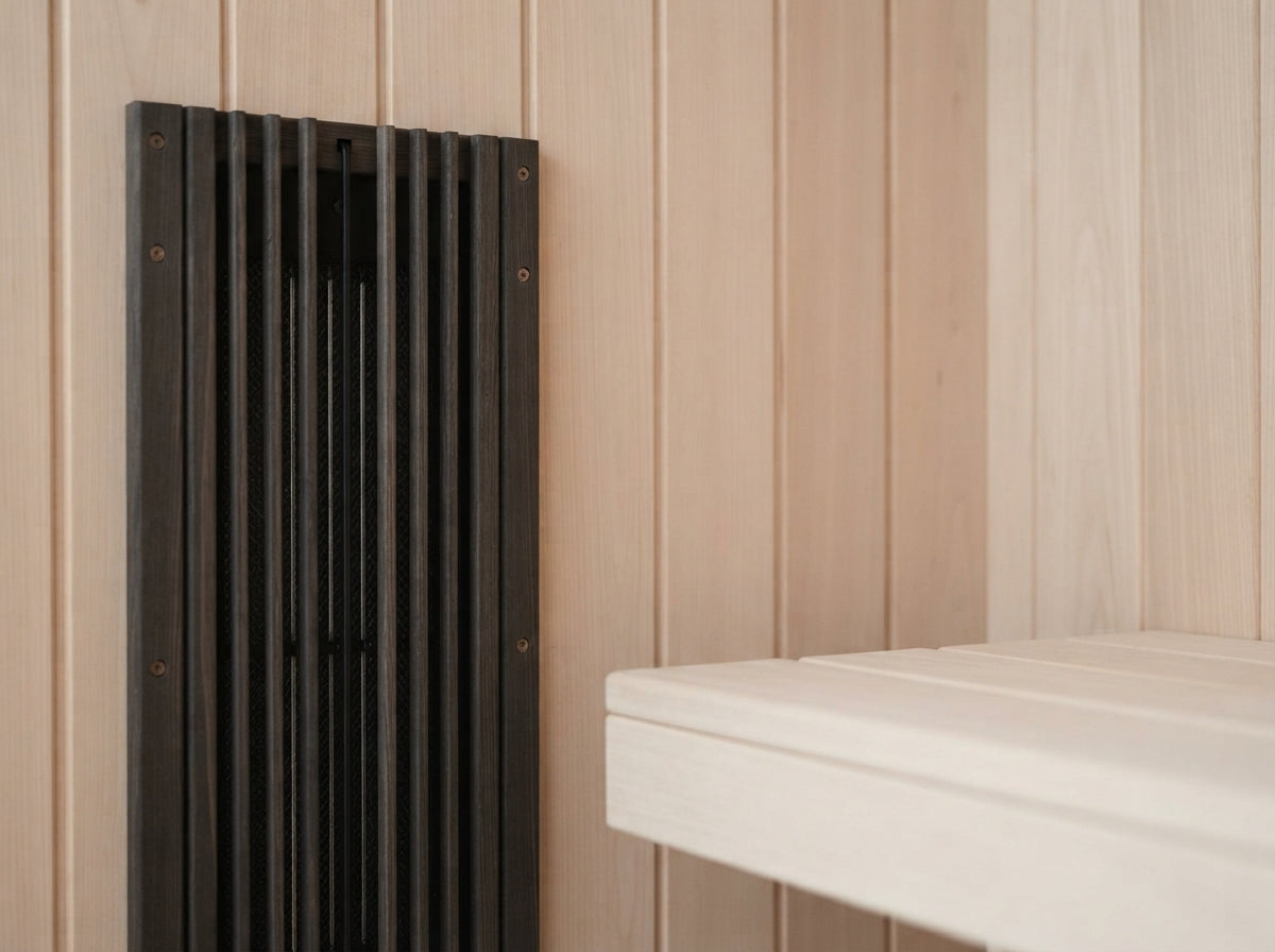 Carbon infrared emitter panel behind a slatted guard in a hemlock sauna cabin, switched off